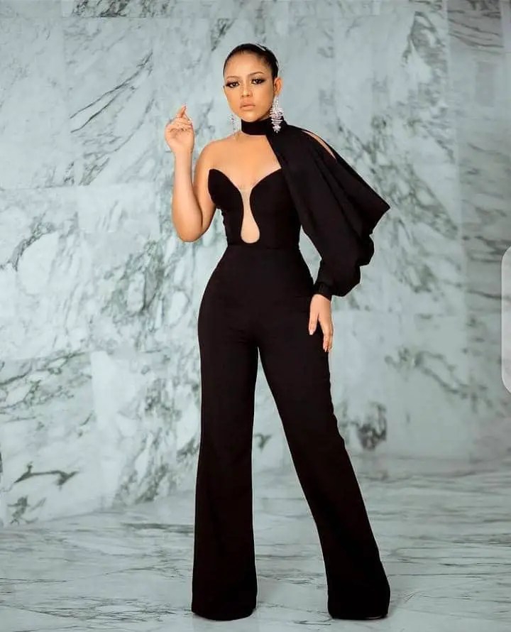 lady wearing black jumpsuit with statement sleeve