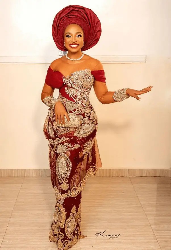 smiling lady wearing red gele with asoebi outfit