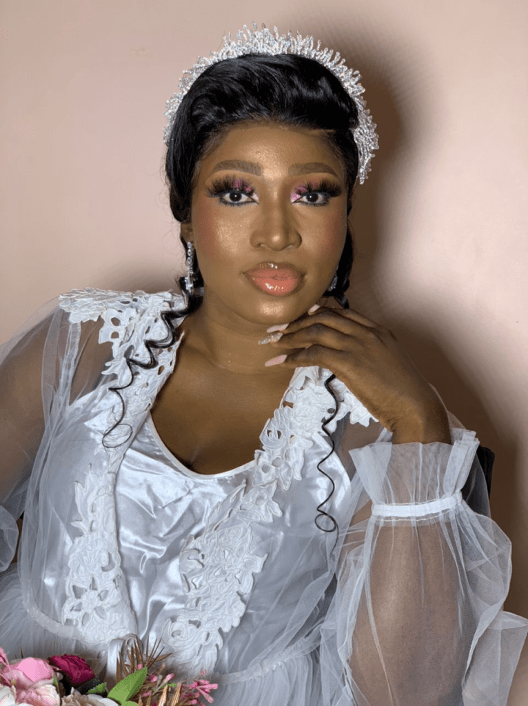 headshot of dark lady wearing makeup for her white wedding