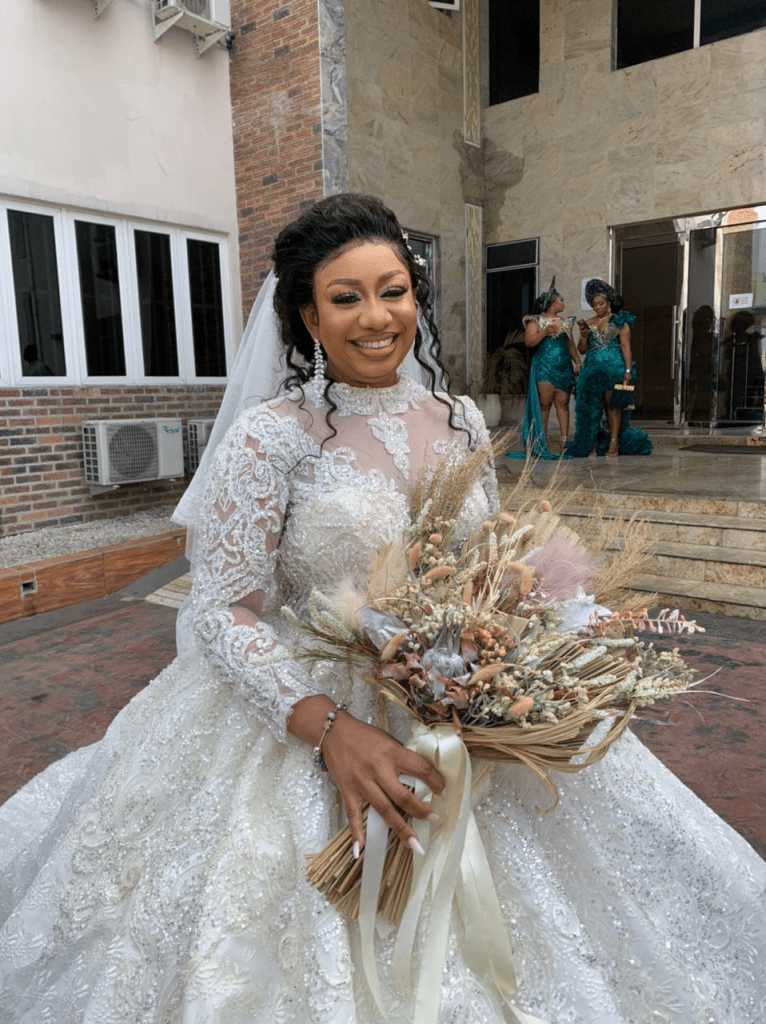smiling bride wearing makeup for her white wedding