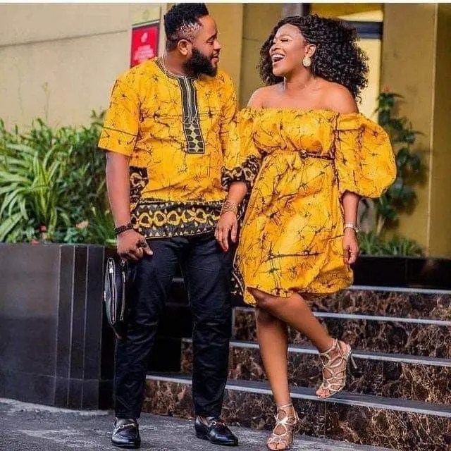 husband and wife rocking matching ankara outfits in front of their house
