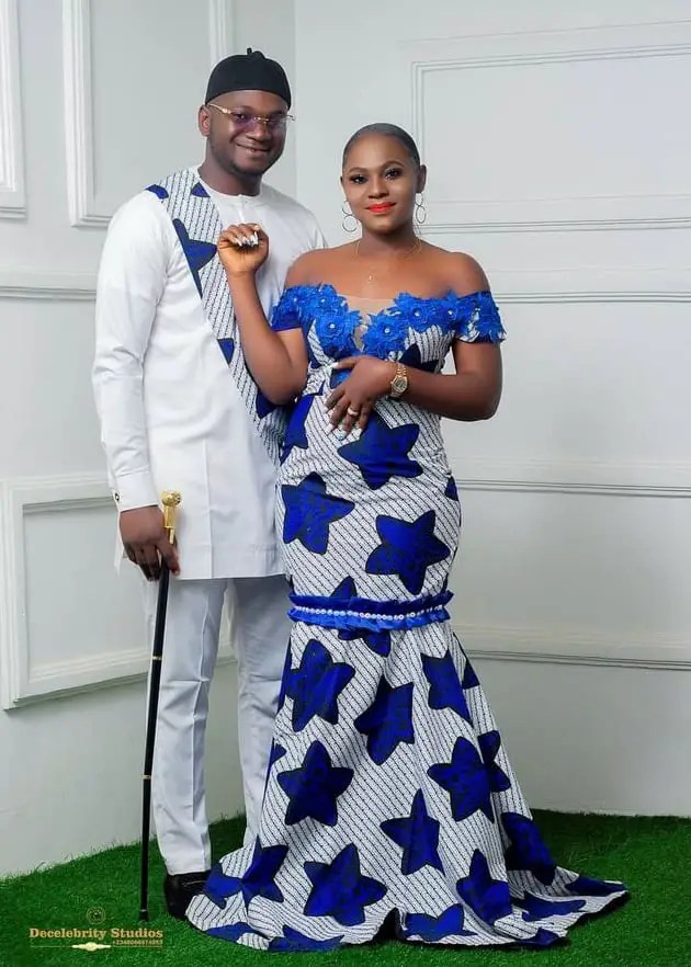 lady wearing ankara gown with her man wearing white outfit with a touch of her ankara