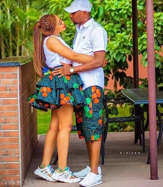 couple wearing short ankara bottoms with white tops and sneakers