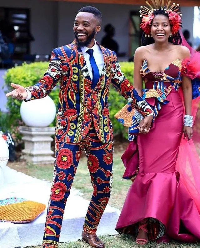 smiling man wearing ankara suit with smiling lady wearing dinner gown with matching ankara