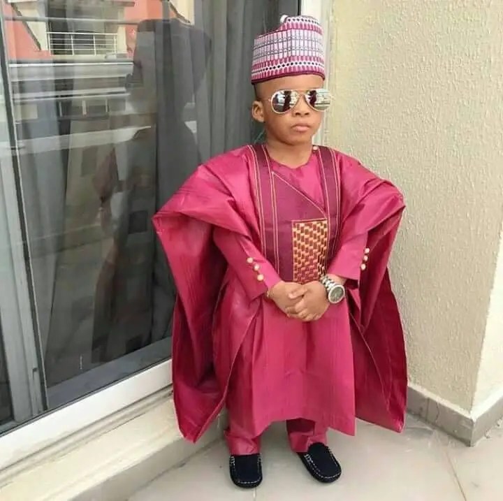 boy wearing red agbada with cap