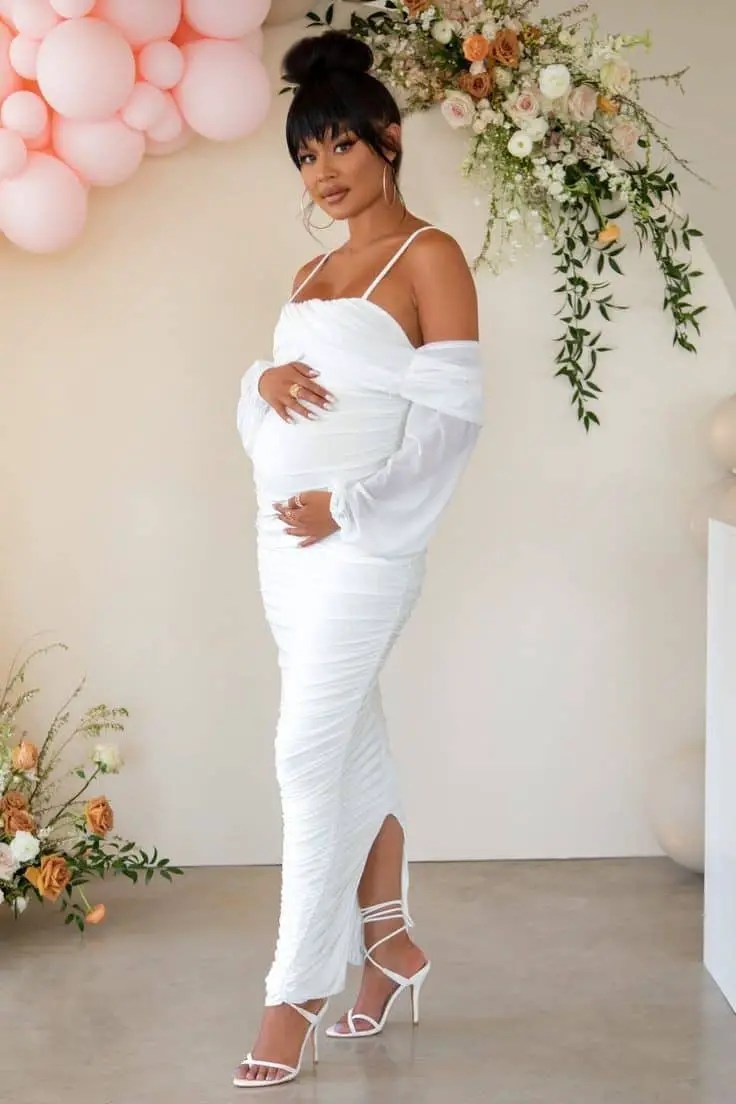Lady wearing all white fitted outfit while pregnant