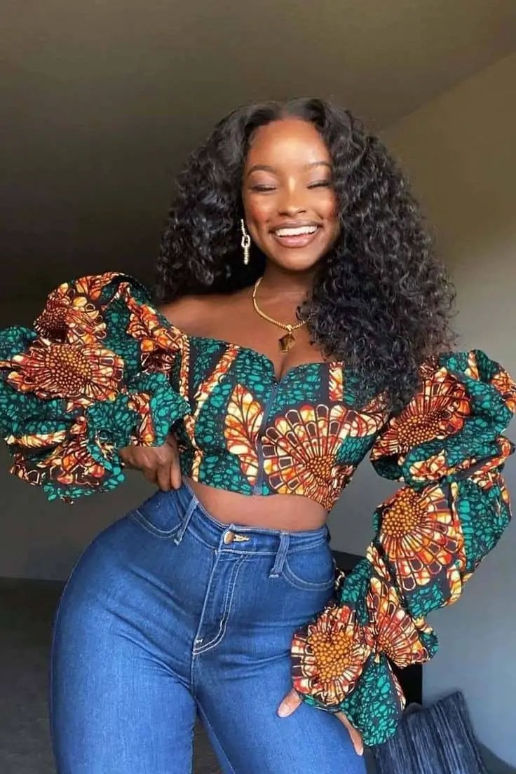 A smiling woman wearing jeans and ankara top for a birthday event