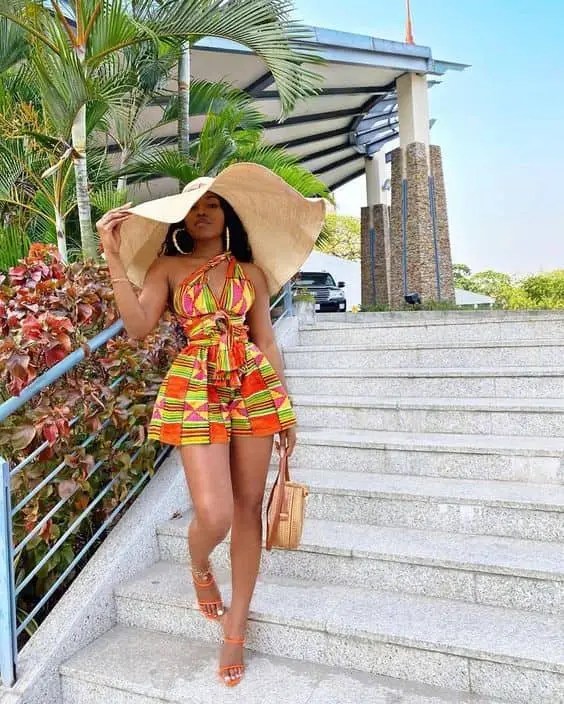 Woman wearing a big hard and short Kente dress
