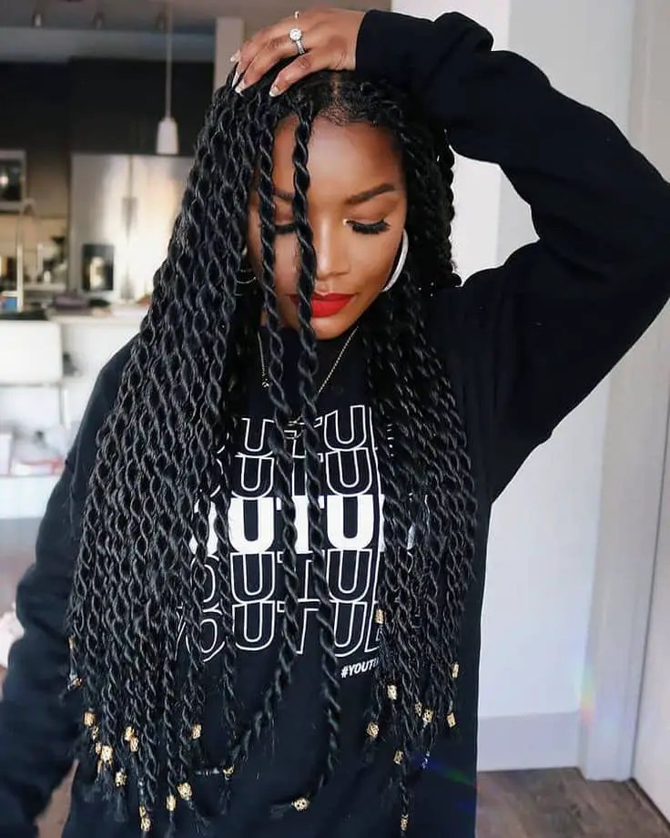 lady wearing Senegalese braids and placing a hand on her head
