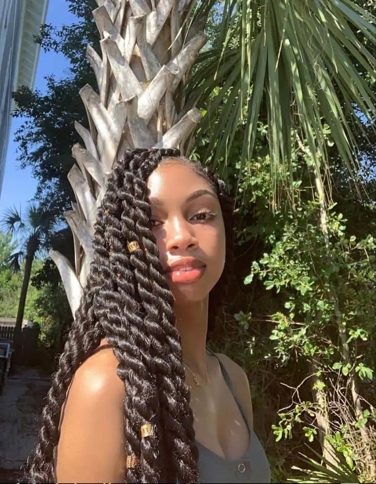 A long senegalese braid woman taking a selfie in the sun
