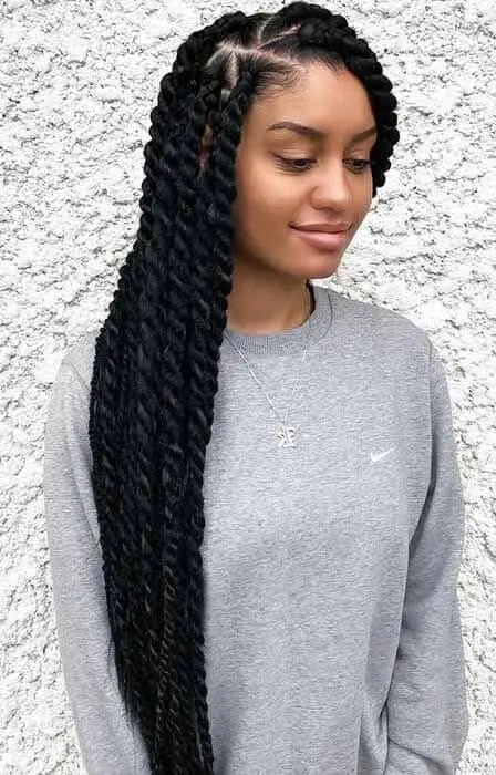 Woman in a sweater shaking a Senegalese braid