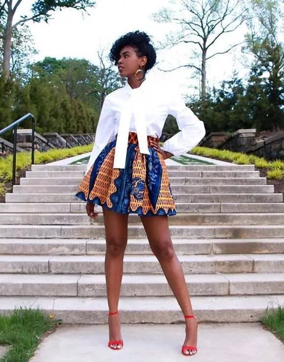 lady wearing white shirt and ankara mini flared skirt