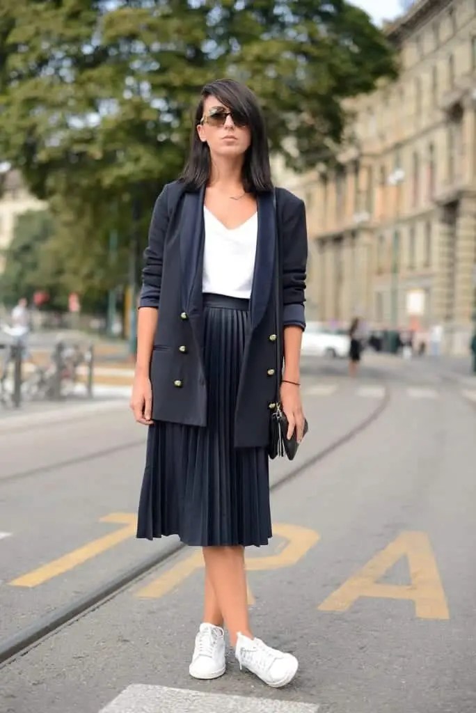 A woman wearing a black jacket that matches the flared skirt