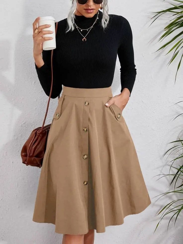 Woman wearing a brown flared skirt and a black turtleneck top