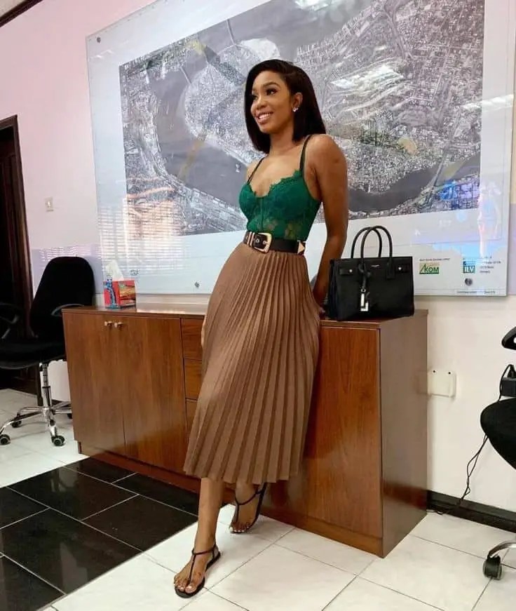 lady wearing green bodysuit with midi flared skirt