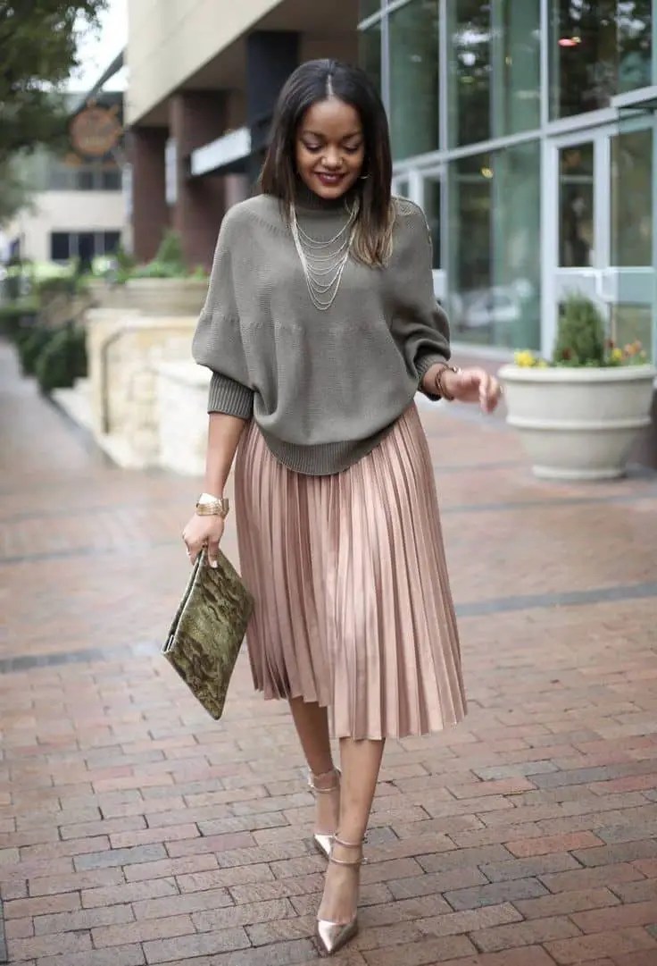 A woman wearing a sweater on a flared skirt