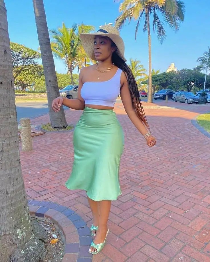 A woman wearing a midi skirt and a crop top