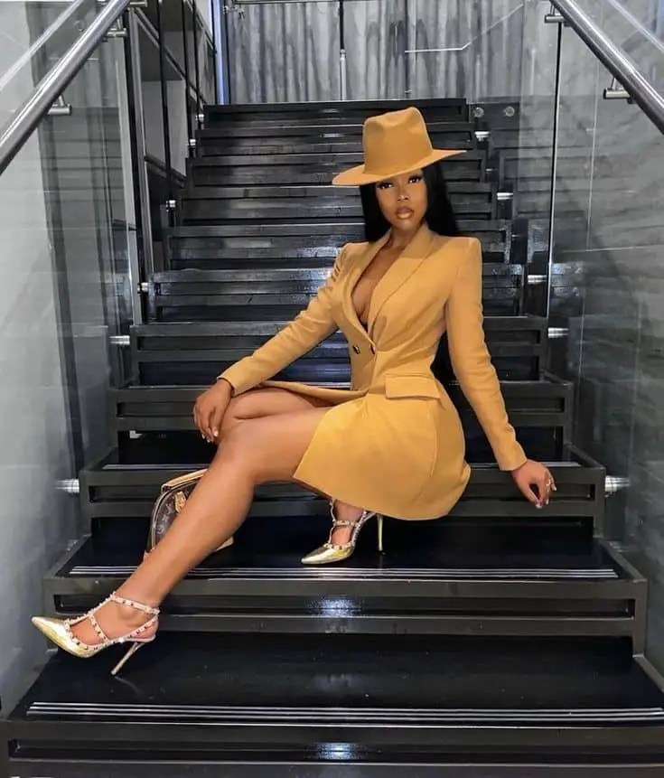 Woman wearing a hat and an orange blazer dress