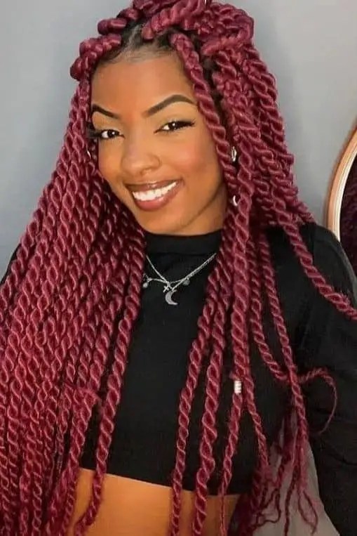 smiling lady wearing red long Senegalese twists