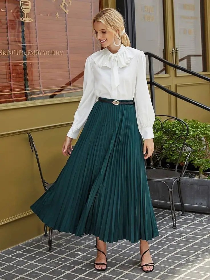 Woman wearing a green midi flared skirt and a white shirt