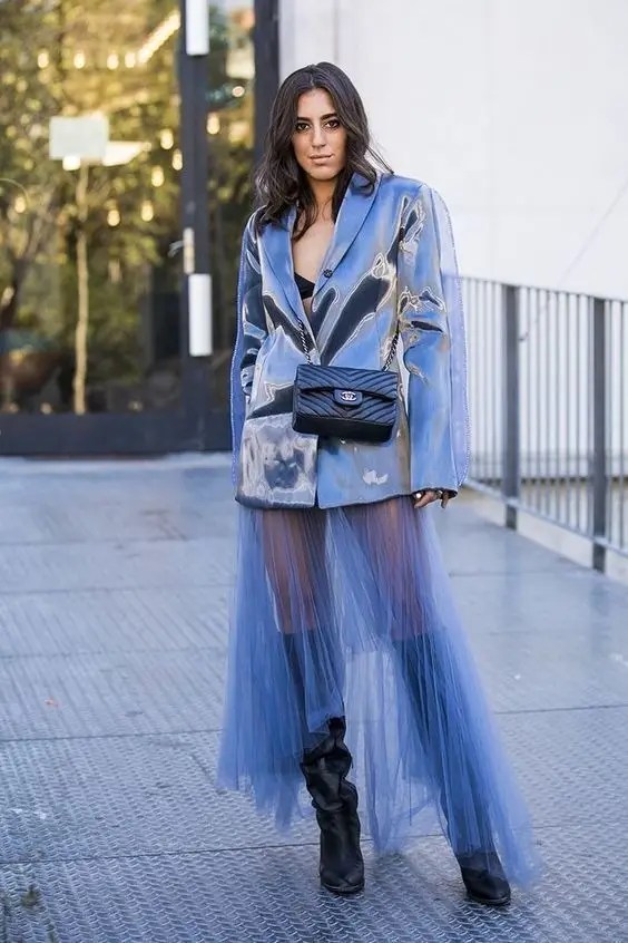A woman wearing a sheer dress layered with a jacket