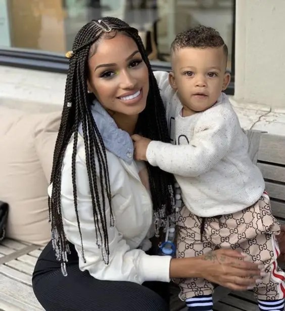 Smiling woman wearing fulani braids with little boy