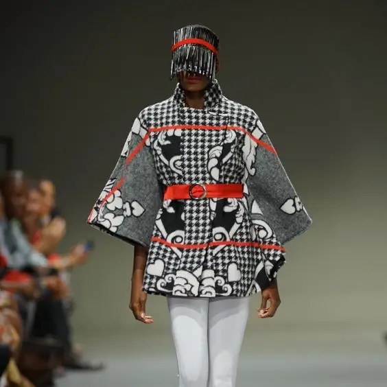 A woman standing on the runway wearing clothes made from Lesotho fabrics