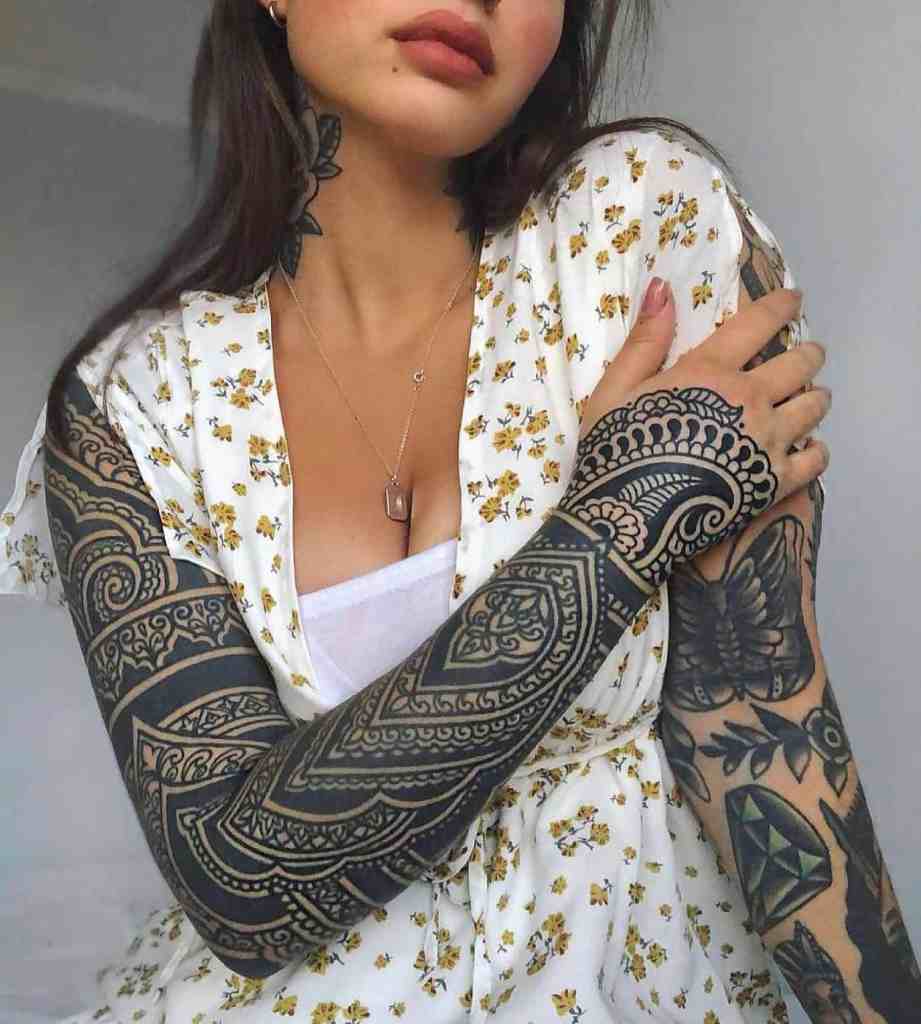 lady wearing a tribal tattoo sleeve on one arm