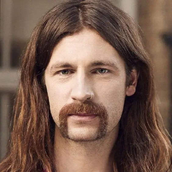 Man with long hair spotting horse shoe mustache style