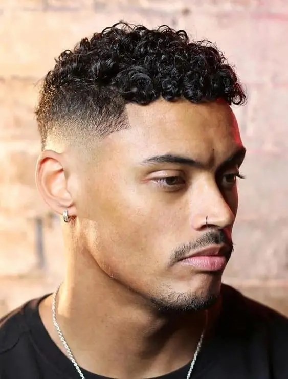Man with earrings wearing men's curly hairstyle