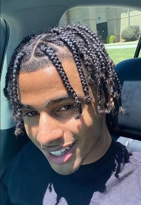 Smiling man rocking braided hairstyle for men