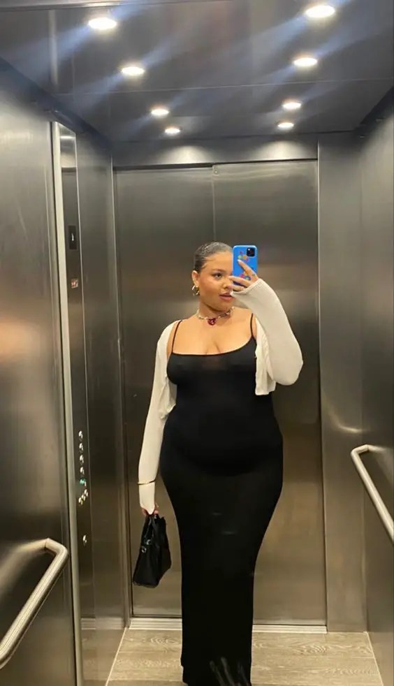 Woman layered with cropped jacket over black bodycon dress