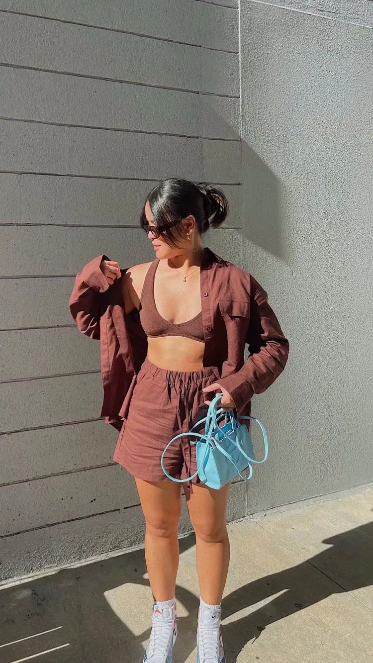 Woman wearing coordinated shorts and shirt with blue handbag