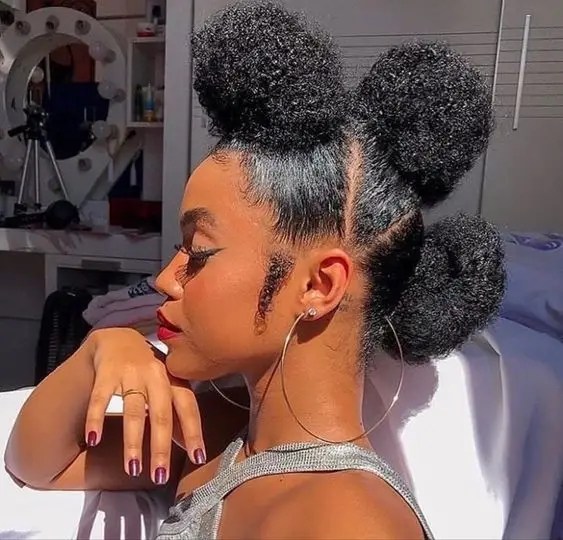 3 A woman arranging her natural hair with a puff