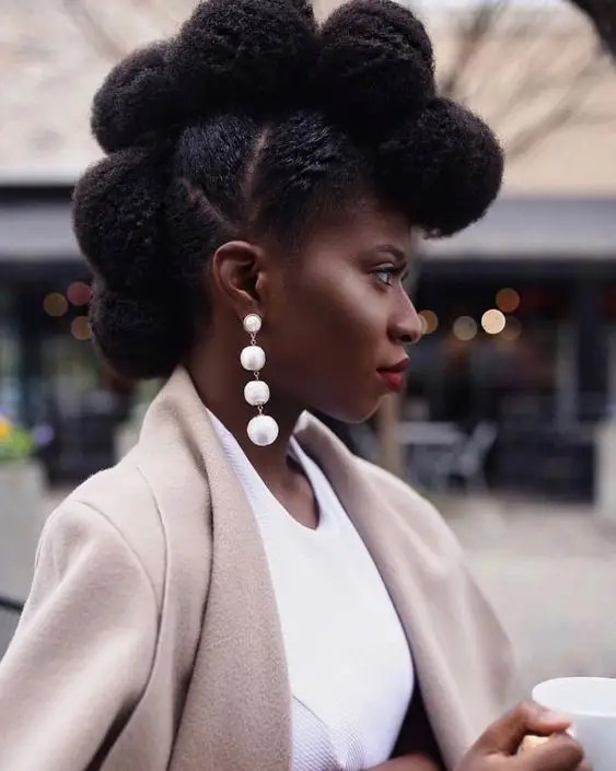 Woman styling her natural hair into an afro-hawk