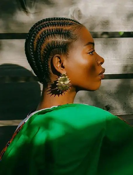 Side view of woman rocking short cornrows