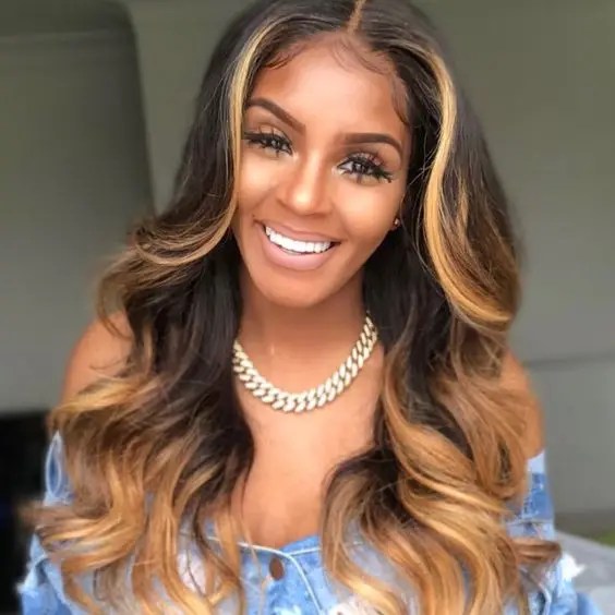 Smiling woman rocking blonde highlights in dark hair