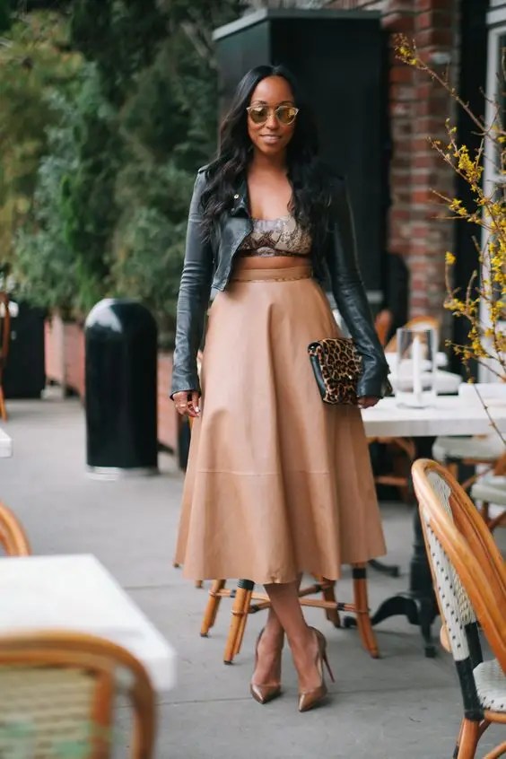 A woman wearing a midi skirt and a jacket