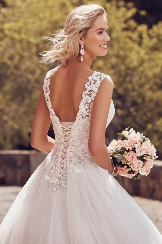 Woman wearing corset wedding dress with bunch of flowers