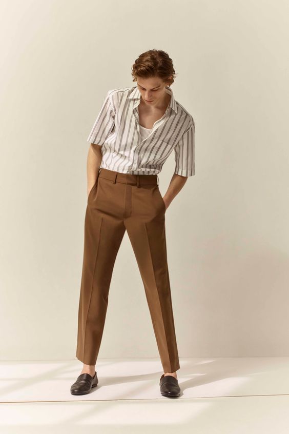a guy wearing brown high-rise pants with a striped shirt