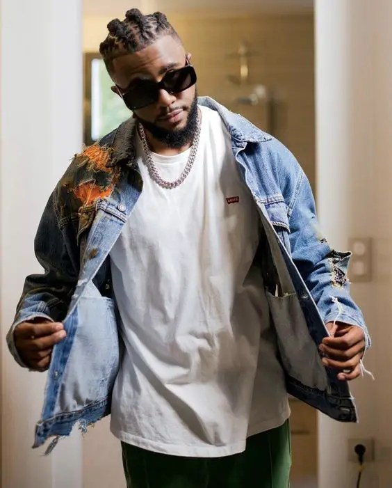 Man wearing men's braided short dreads style with sunglasses and silver necklace and jean jacket