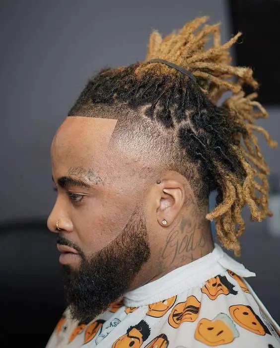 Man with nose ring showing off ombre blonde dreadlocks