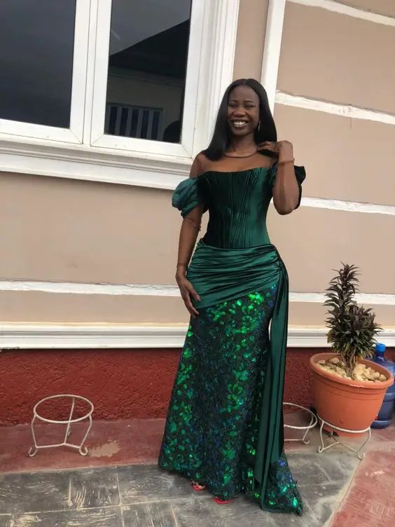 Smiling woman in green off-shoulder lace gown