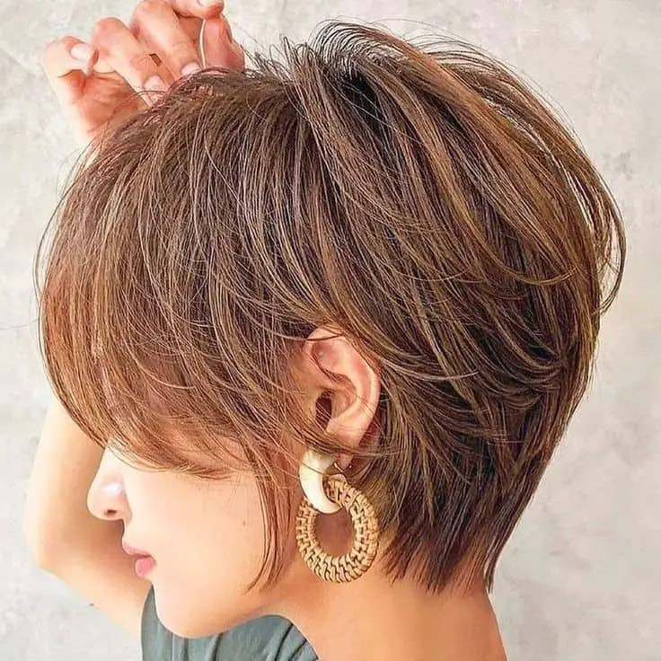 Woman with short layered hair and hoop earrings