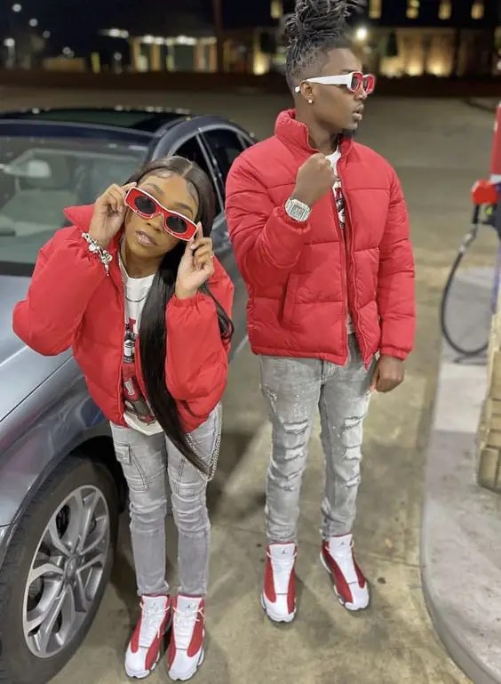 Couple wearing jeans, red puffer jacket and red sneakers as Valentine's outfit for couples