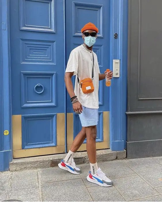 A man wearing shorts, a t-shirt, sunglasses and a beanie for election day