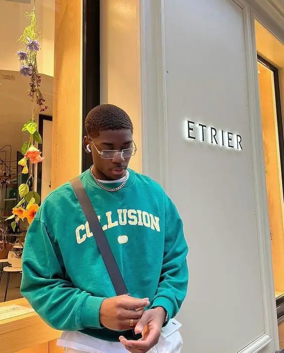 A man wearing a sling bag and a green sweater as his election day outfit