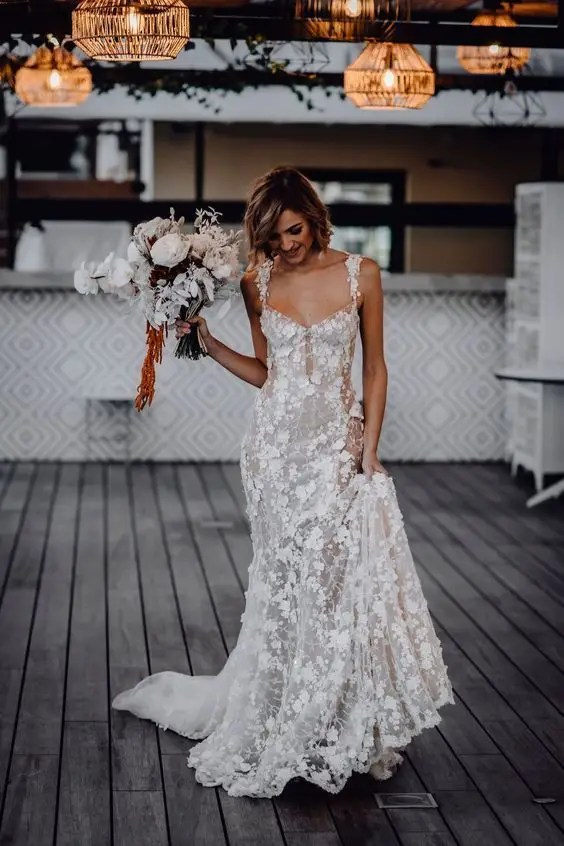 Woman in lace wedding dress holding flowers