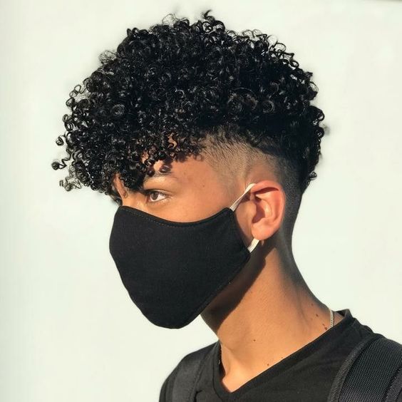 Man wearing a face mask while holding cute curly hair