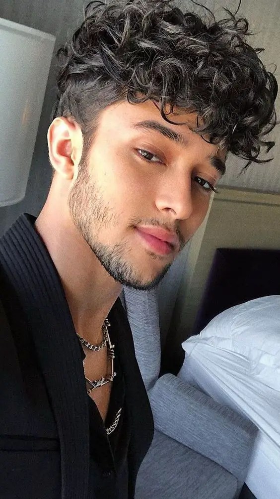 cute guy rocking pompadour curly hairstyle for men